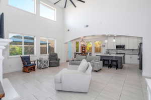 Living area with arched walkways, a high ceiling, and light tile patterned flooring
