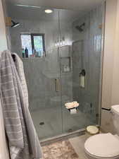 Bathroom with a stall shower and tile patterned flooring