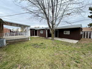 Rear view of house featuring a patio and a lawn