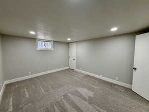 Basement with light colored carpet and recessed lighting