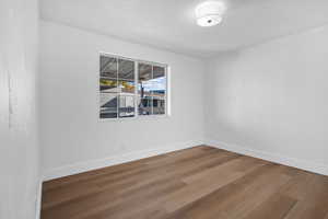 Empty room featuring wood finished floors and a textured ceiling
