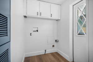 Laundry room with light wood-style floors, washer hookup, a heating unit, cabinet space, and gas dryer hookup