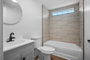Bathroom featuring vanity, washtub / shower combination, wood finished floors, and a textured ceiling