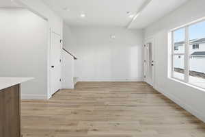 Foyer with light wood-style flooring, stairway, and recessed lighting
