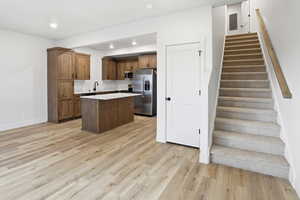Kitchen featuring a center island, light countertops, appliances with stainless steel finishes, light wood-style floors, and recessed lighting