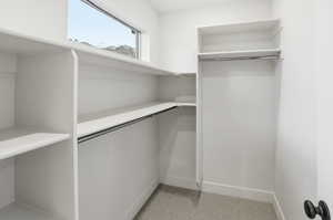 Walk in closet featuring light colored carpet