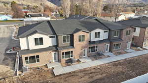 View of front of property featuring roof with shingles, a mountain view, a residential view, and brick siding