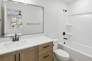 Full bath with vanity, shower / bathtub combination, and ceiling fan