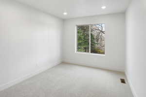 Empty room featuring carpet floors and recessed lighting