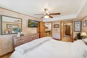 Bedroom with a textured ceiling, light wood-type flooring, and ceiling fan