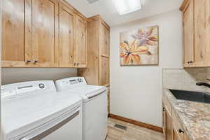 Laundry room with cabinet space, a textured ceiling, and independent washer and dryer