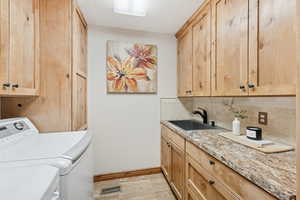 Laundry area featuring cabinet space, a textured ceiling, and washing machine and dryer