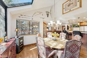 Dining room with light wood-type flooring, recessed lighting, and a chandelier