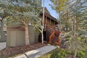View of front of house featuring stairs and a wooden deck