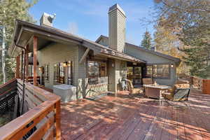 Wooden deck featuring an outdoor fire pit and a sunroom