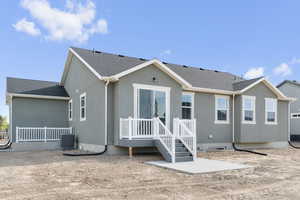Back of property featuring roof with shingles, a patio area, stucco siding, and a wooden deck