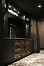 Bar area with glass insert cabinets, light stone countertops, recessed lighting, and gray cabinetry