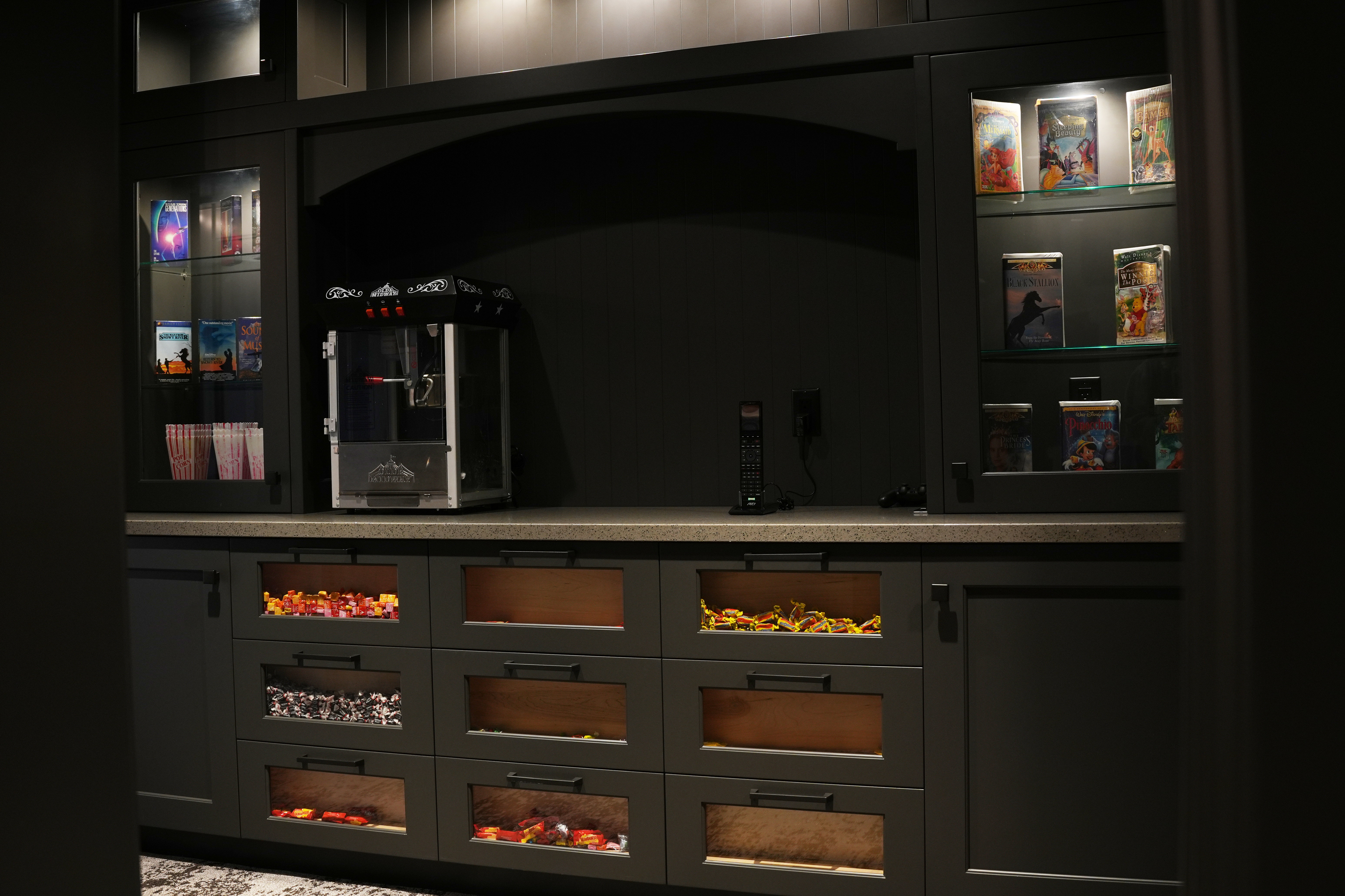 Bar area featuring glass insert cabinets, gray cabinets, and light stone countertops