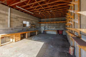 Garage featuring concrete block wall and a workshop area