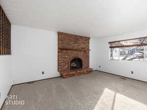 Living room with a fireplace and carpet flooring