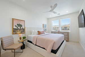 Bedroom with light carpet, a ceiling fan, and recessed lighting