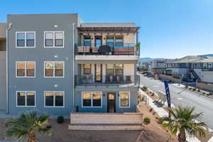 Rear view of property featuring stucco siding, a balcony, and a residential view