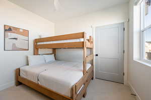 Bedroom featuring light colored carpet and a ceiling fan