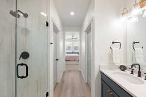 Full bath featuring vanity, ensuite bath, light wood-style flooring, a marble finish shower, and recessed lighting