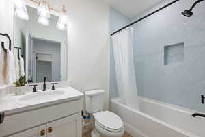 Full bathroom with shower / tub combo with curtain and vanity
