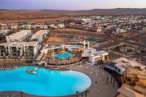 Pool at dusk featuring a mountain view and a patio