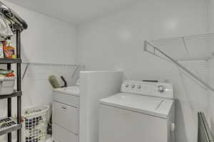 Laundry area featuring separate washer and dryer and a baseboard radiator