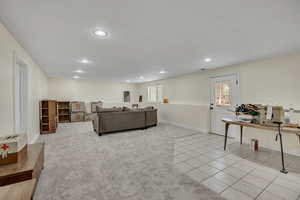 Living room featuring light colored carpet, light tile patterned floors, and recessed lighting