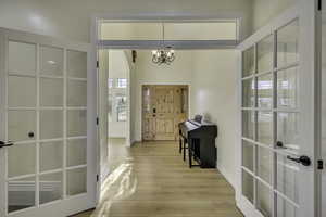 Entryway with light wood-type flooring and a chandelier