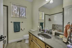 Full bathroom with vanity, a shower, and light wood-type flooring