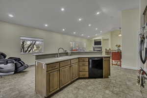 Kitchen with open floor plan, vaulted ceiling, black dishwasher, a center island with sink, and stone finish floors