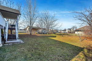 Fenced backyard featuring stairway, a residential view, and a deck