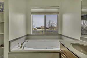 Full bathroom with a jetted tub and vanity