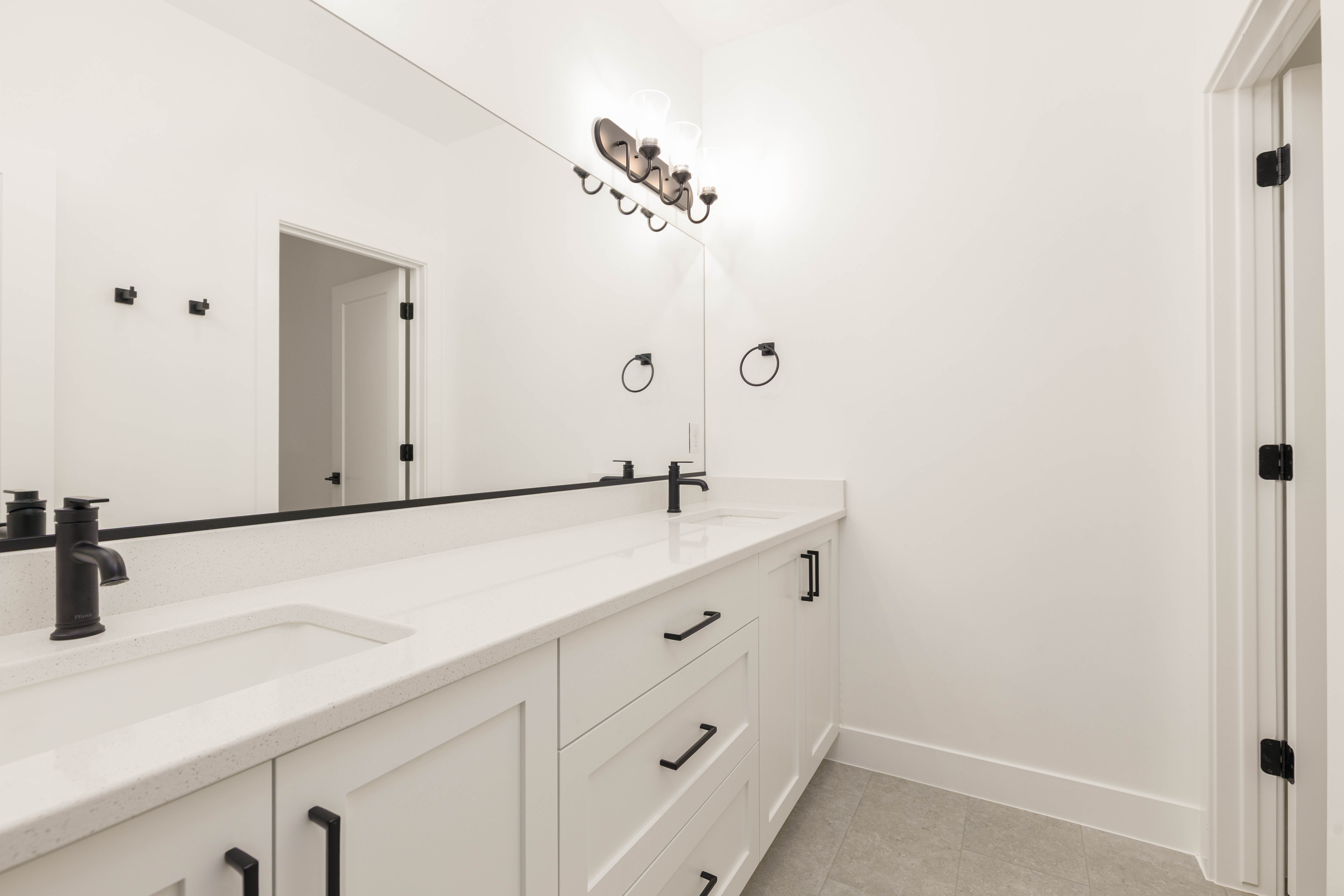 Full bathroom featuring double vanity and light tile patterned floors