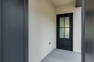 Doorway to property featuring stucco siding