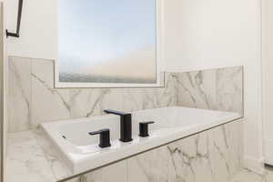 Full bathroom with a bath, marble tiled floors, and healthy amount of natural light