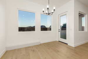 Unfurnished dining area with light wood-style flooring and a chandelier