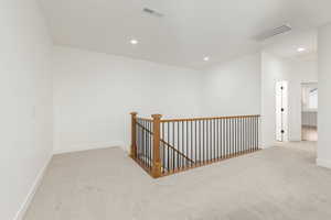 Hall with an upstairs landing, light carpet, and recessed lighting
