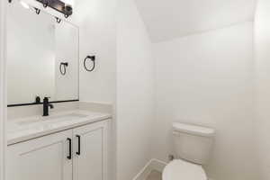 Half bath featuring vanity and vaulted ceiling