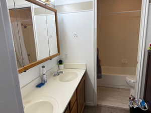 Full bath with double vanity, a bath, and a shower with shower curtain