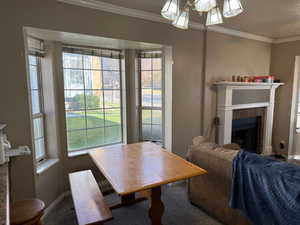 Carpeted dining room featuring a tiled fireplace, ornamental molding, healthy amount of natural light, and a textured ceiling
