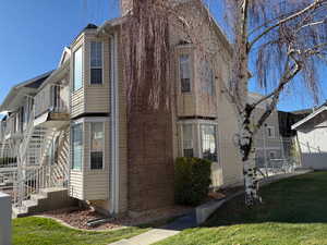 View of side of home featuring stairway and a balcony