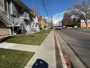 View of asphalt road featuring stairway, sidewalks, curbs, and a residential view