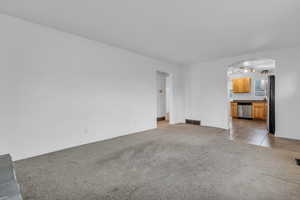 Living room transitions to kitchen and hallway leading to bedroom and bathroom.