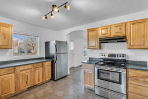 Well-maintained kitchen with stainless appliances and wood cabinets.