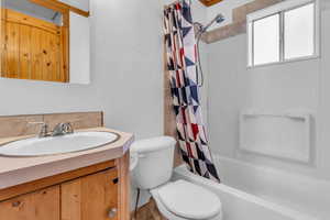 Bathroom featuring vanity and shower / tub combo with tiled floor and storage closet.